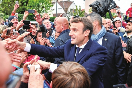 　　在法国勒图凯，“前进”运动候选人埃马纽埃尔·马克龙（中）在投票前向支持者致意。