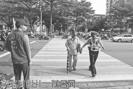 交警扶着老人快速通过十字岗马路。 茂名日报社全媒体记者黎雄摄<br>