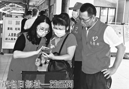 茂湛公司志愿者小敏（左）在电白服务区指导游客使用粤康码。<br>