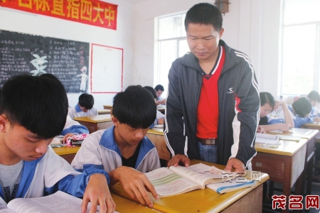吴汉权老师在教室里辅导学生学习。 茂名晚报记者陈兴海摄<br>