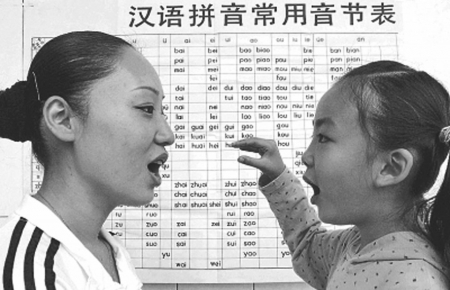 　　一名学生正在教妈妈标准普通话的发音。<br>