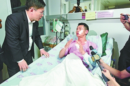 　▶幸存者黄俊雄向中国驻泰国大使吕健（左）讲述逃生经历。